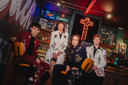Four models wearing bespoke embroidered thrifted suits during an editorial fashion photoshoot at Black Market in Stockton.