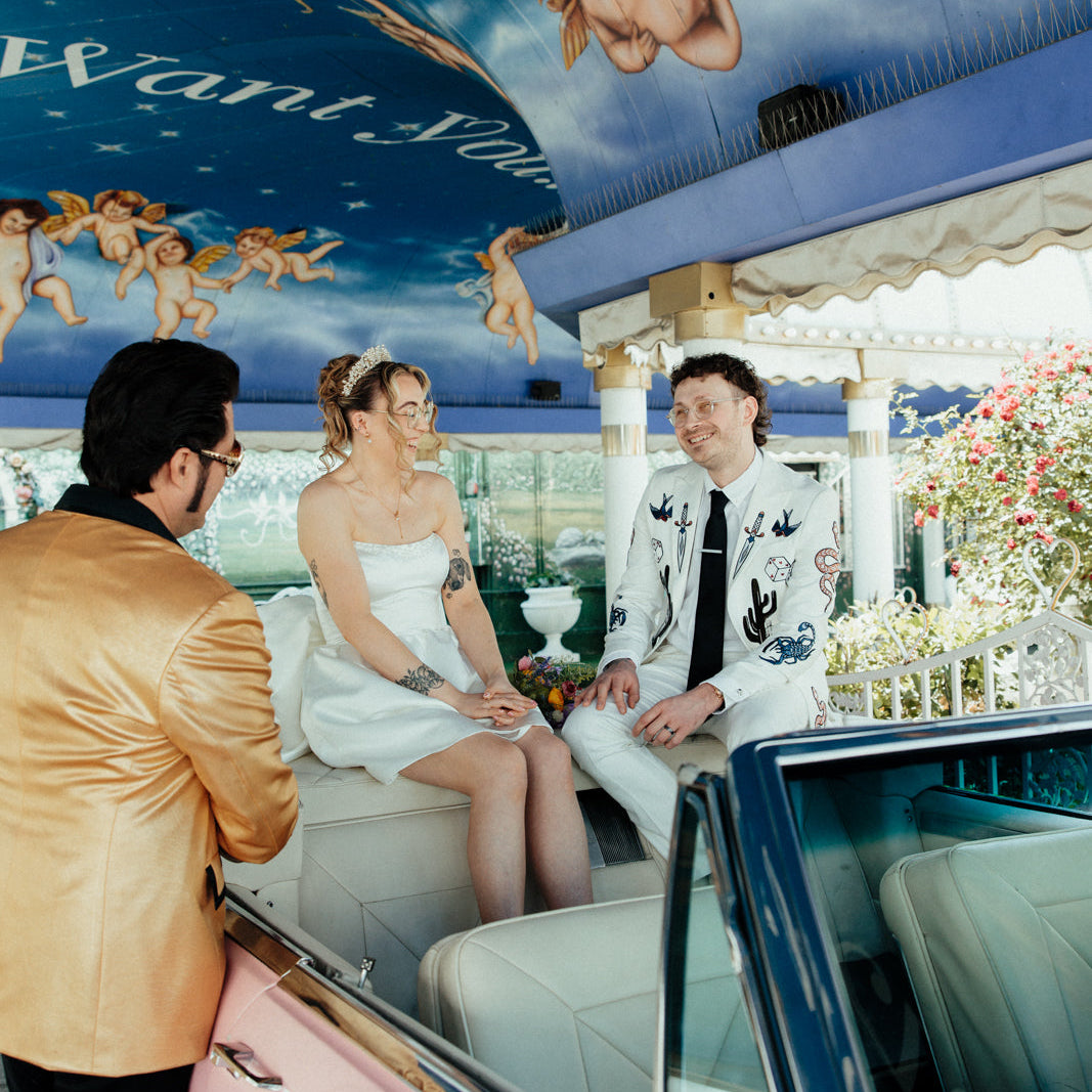 Bespoke embroidered white wedding blazer for a Las Vegas wedding, featuring custom western-inspired and Vegas-themed embroidery details. Luxury made-to-order groom jacket designed for an alternative modern wedding look.