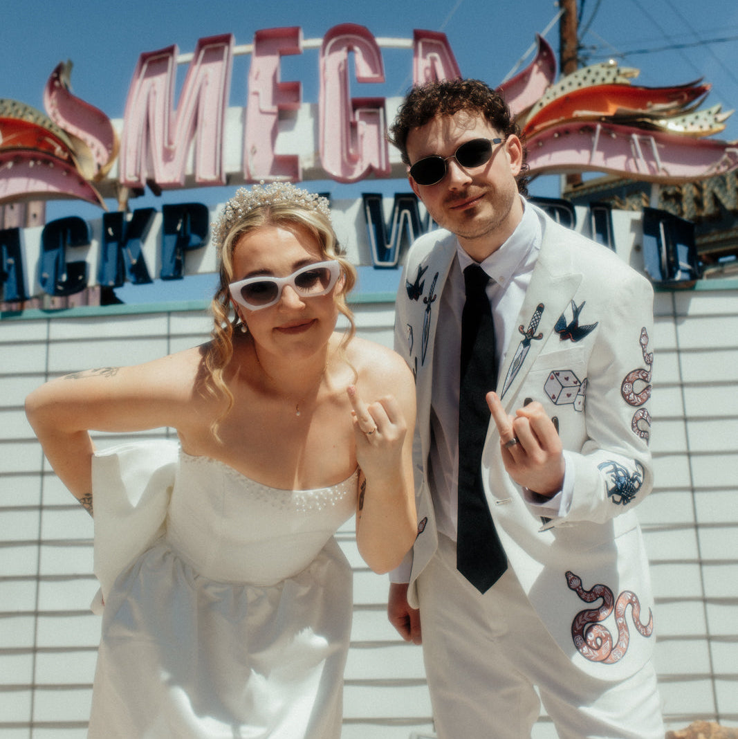 Bespoke embroidered white wedding blazer for a Las Vegas wedding, featuring custom western-inspired and Vegas-themed embroidery details. Luxury made-to-order groom jacket designed for an alternative modern wedding look.