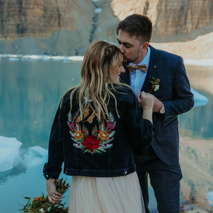 bride wearing a personalised embroidered floral denim jacket during a mountain elopement wedding.