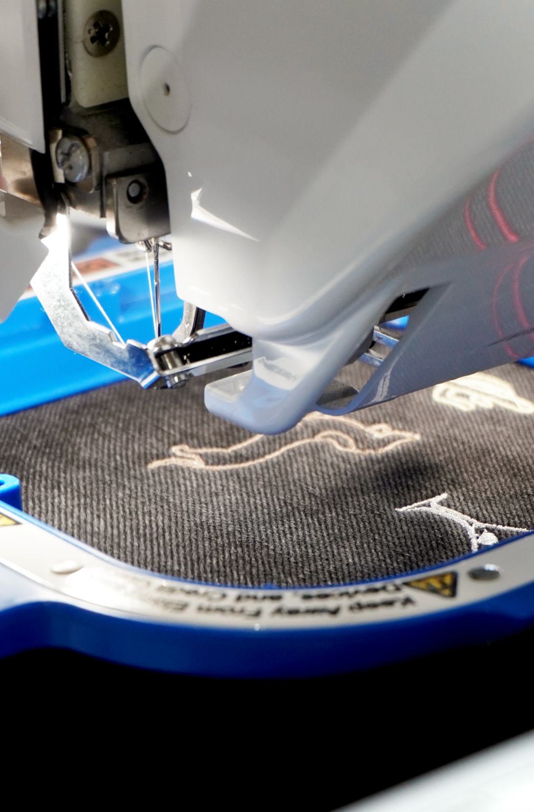 Live embroidery machine stitching a personalised garment during a retail event.